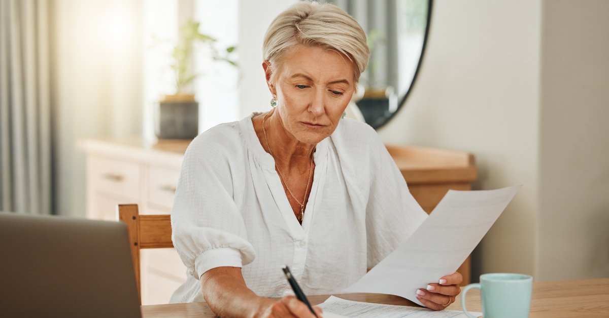 senior woman with notebook writing budget plan