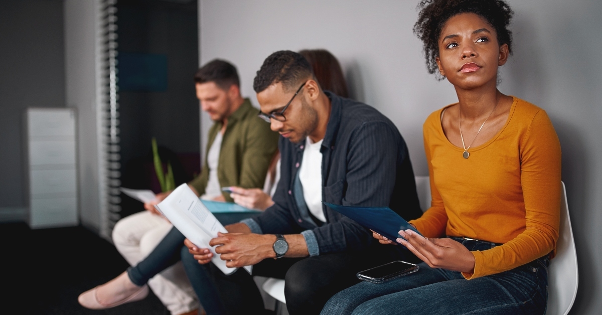 woman sitting in queue with other candidates for job interview