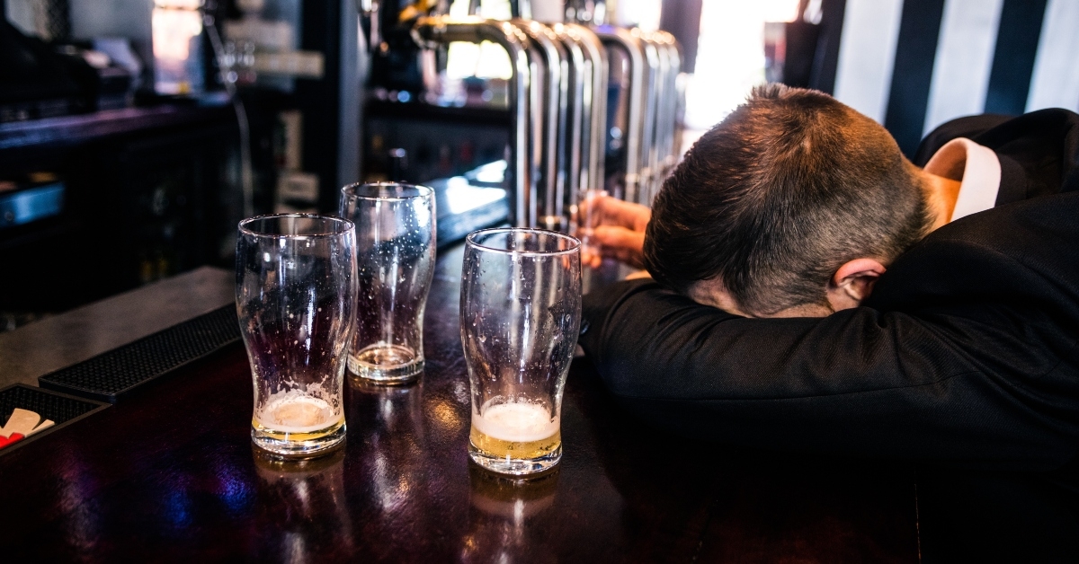 drunk man with empty glasses