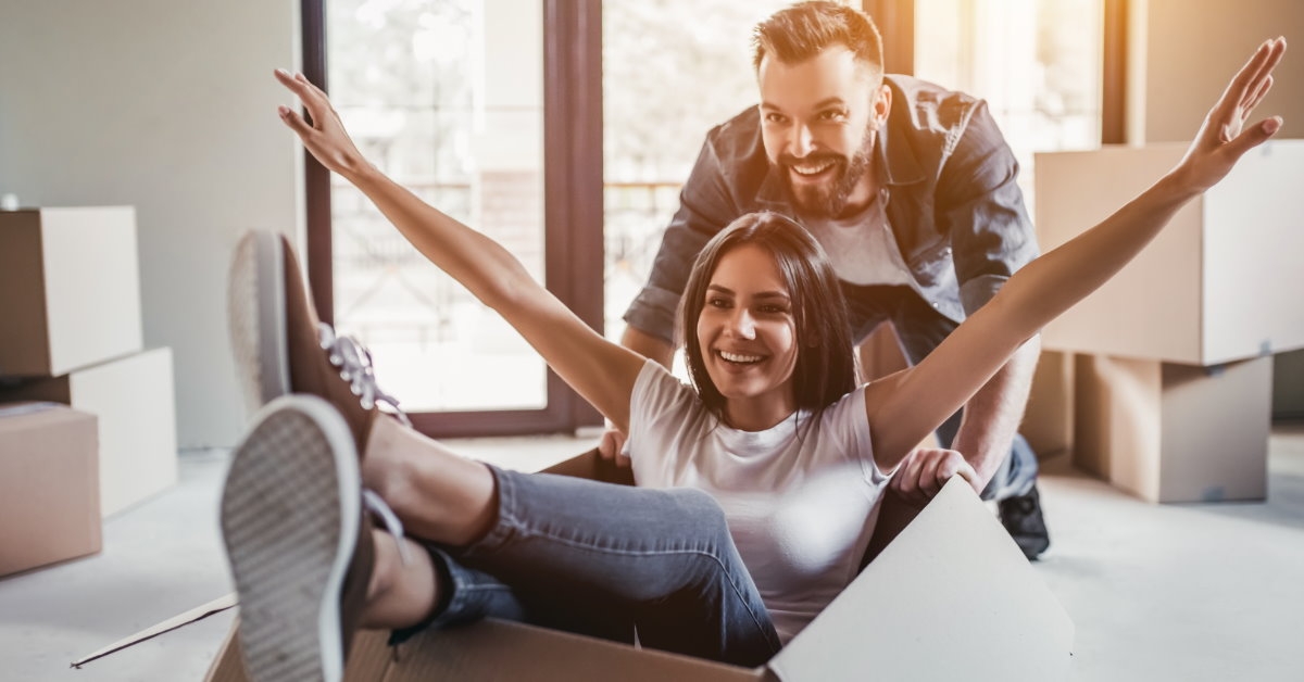 happy couple having fun with moving boxes 