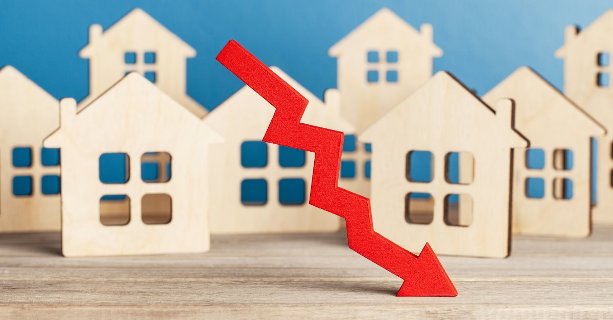 red arrow in downward position with tiny home sculptures in background