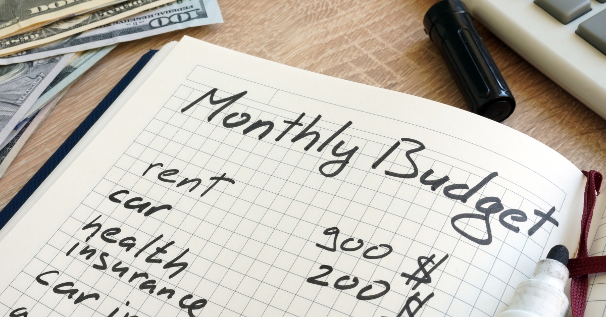 notepad with monthly budget calculations and money