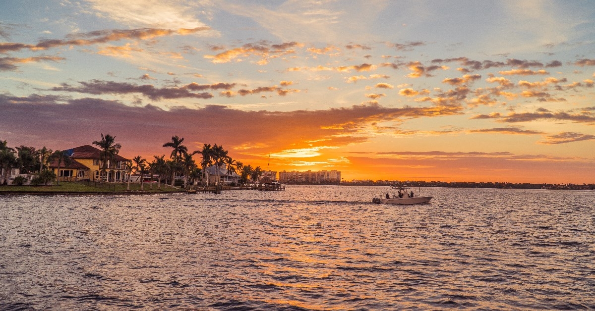 cape coral waterfront with boat and palm trees 