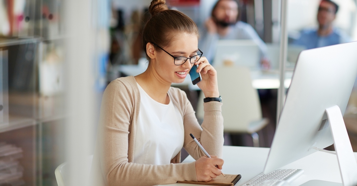 businesswoman working in public relations talking on phone making notes