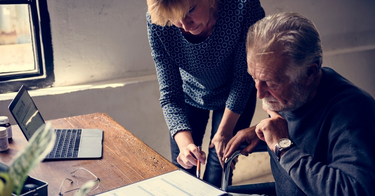elderly man sitting on wheelchair looking at life insurance