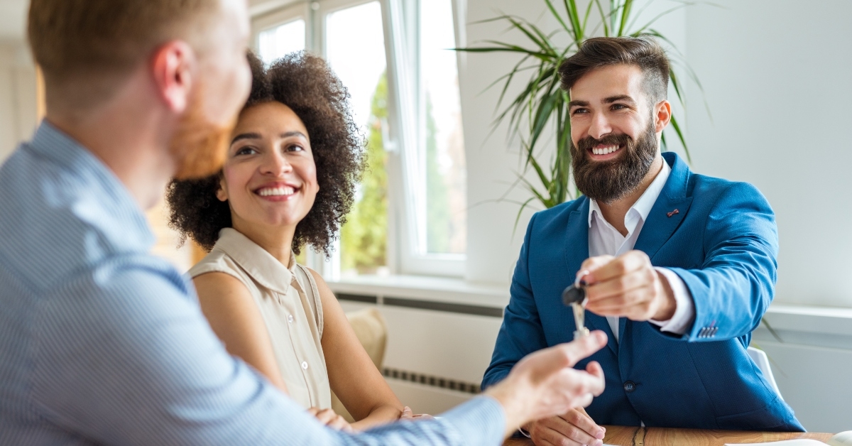 estate agent giving keys to new homeowners