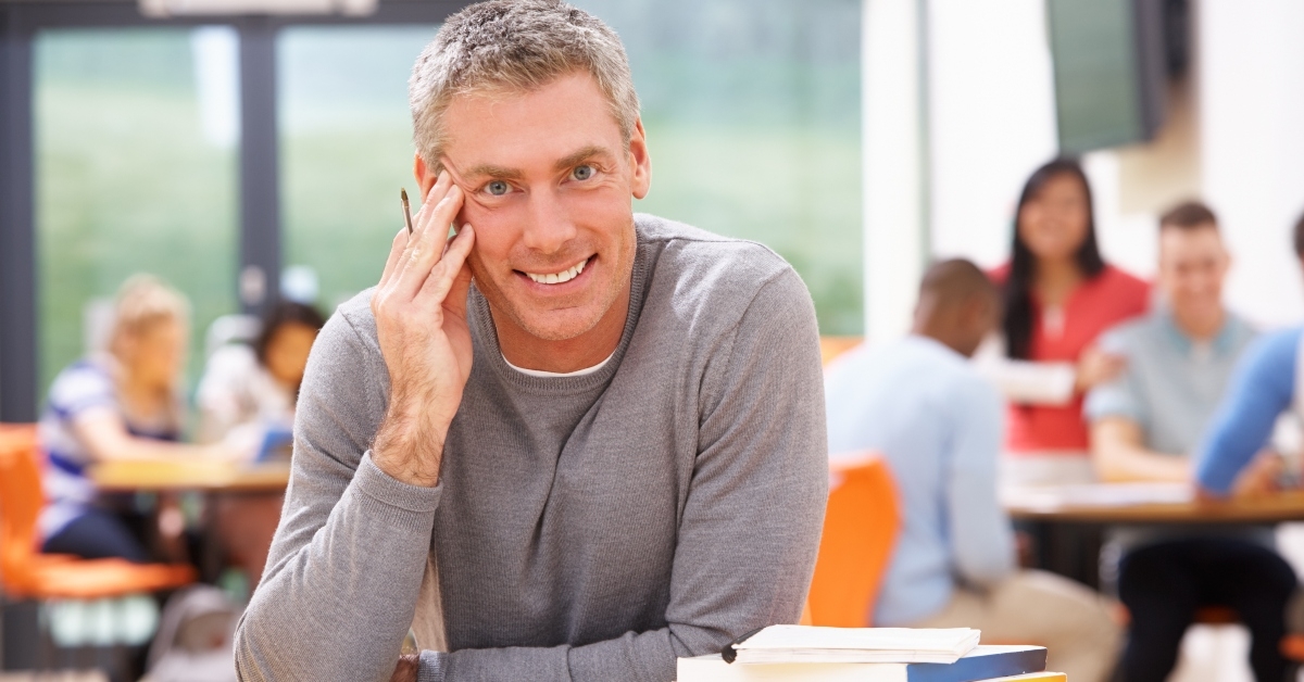 male mature student studying in classroom with books