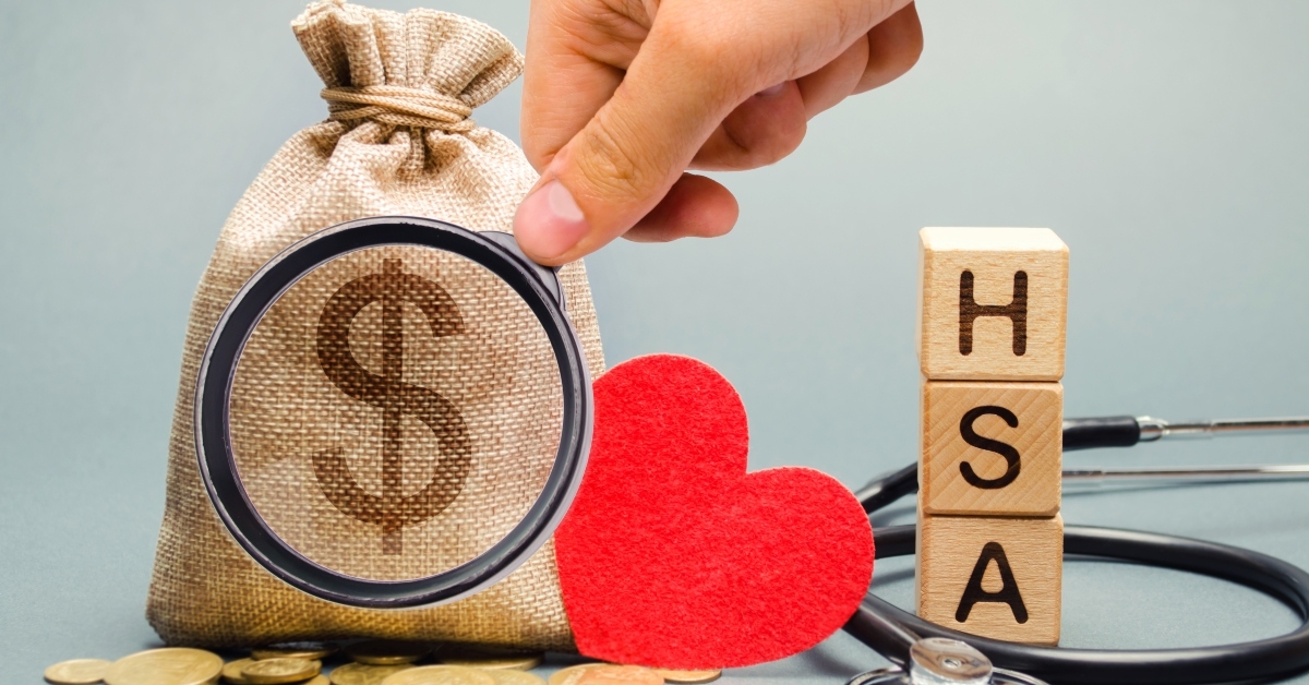 wooden blocks with the word HSA and money bag with stethoscope