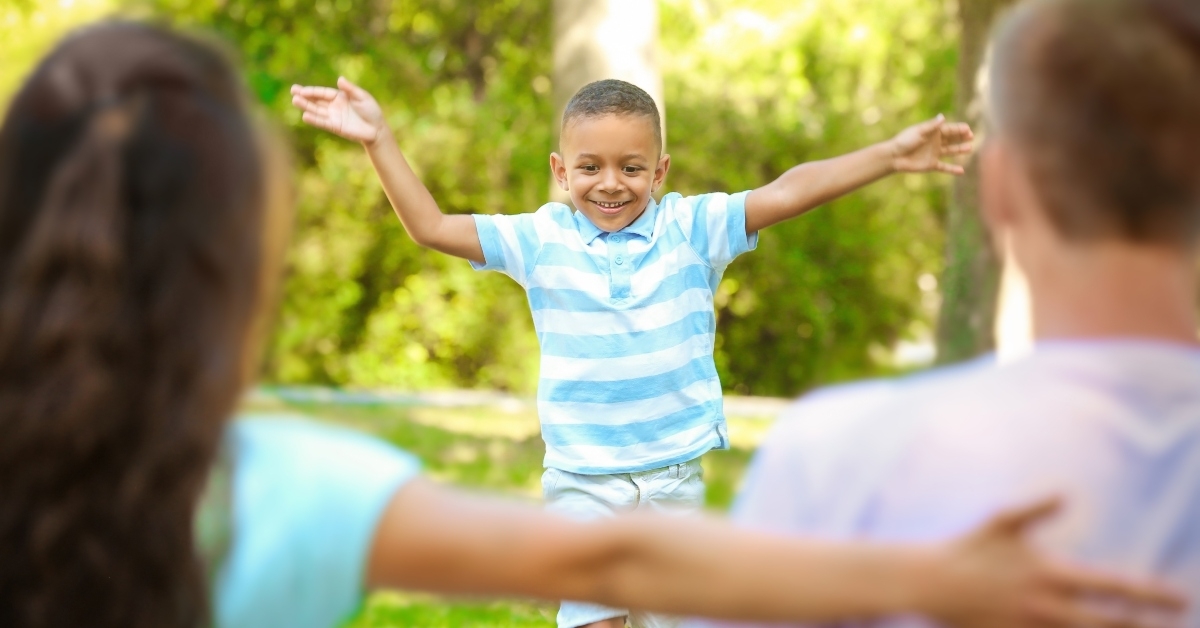young family with adopted african american boy outdoors