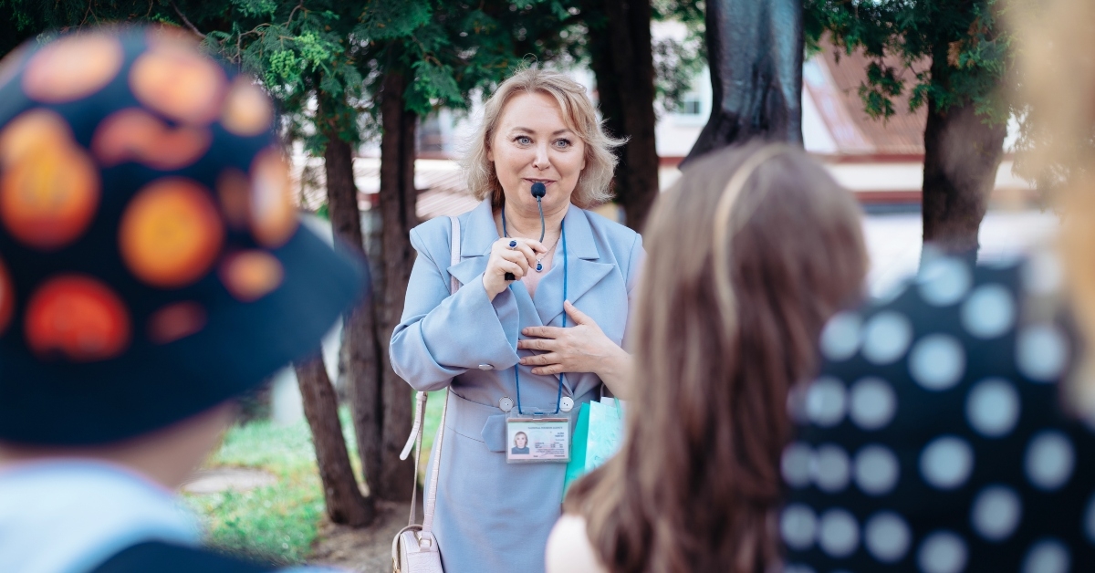 female guide is telling a group of tourists about something