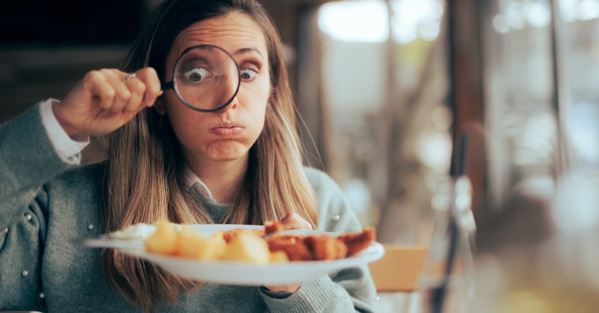 funny food critic checking the restaurant dish with a magnifying glass