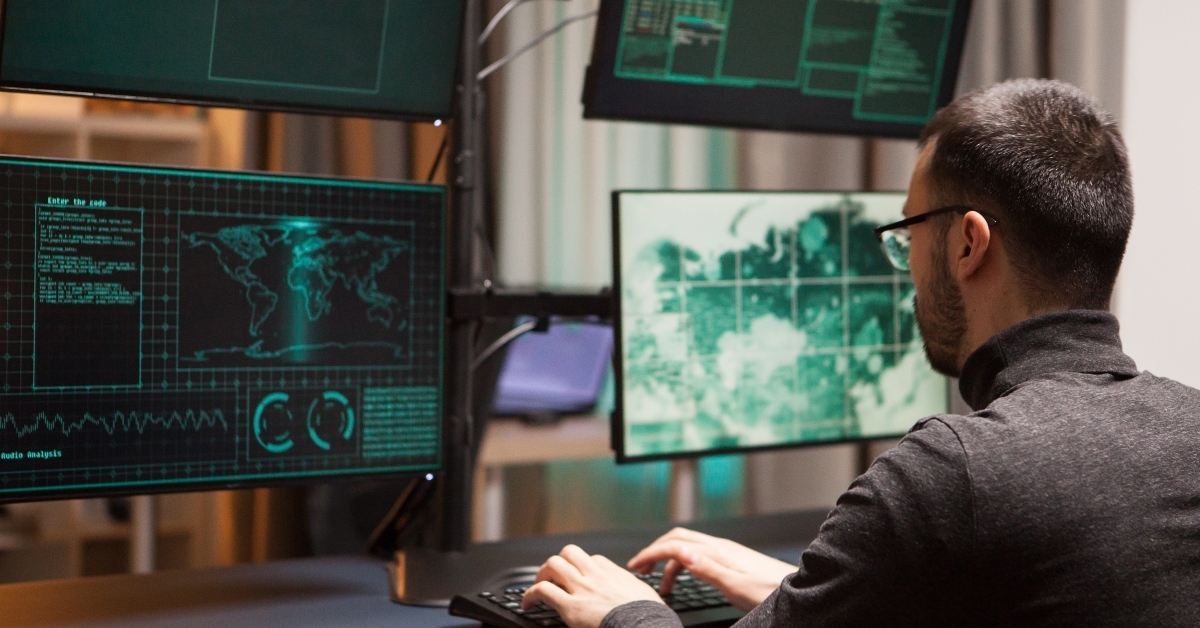 hacker with glasses writing a dangerous virus on computer