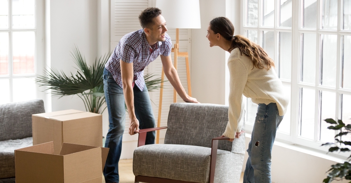 couple carrying modern chair together