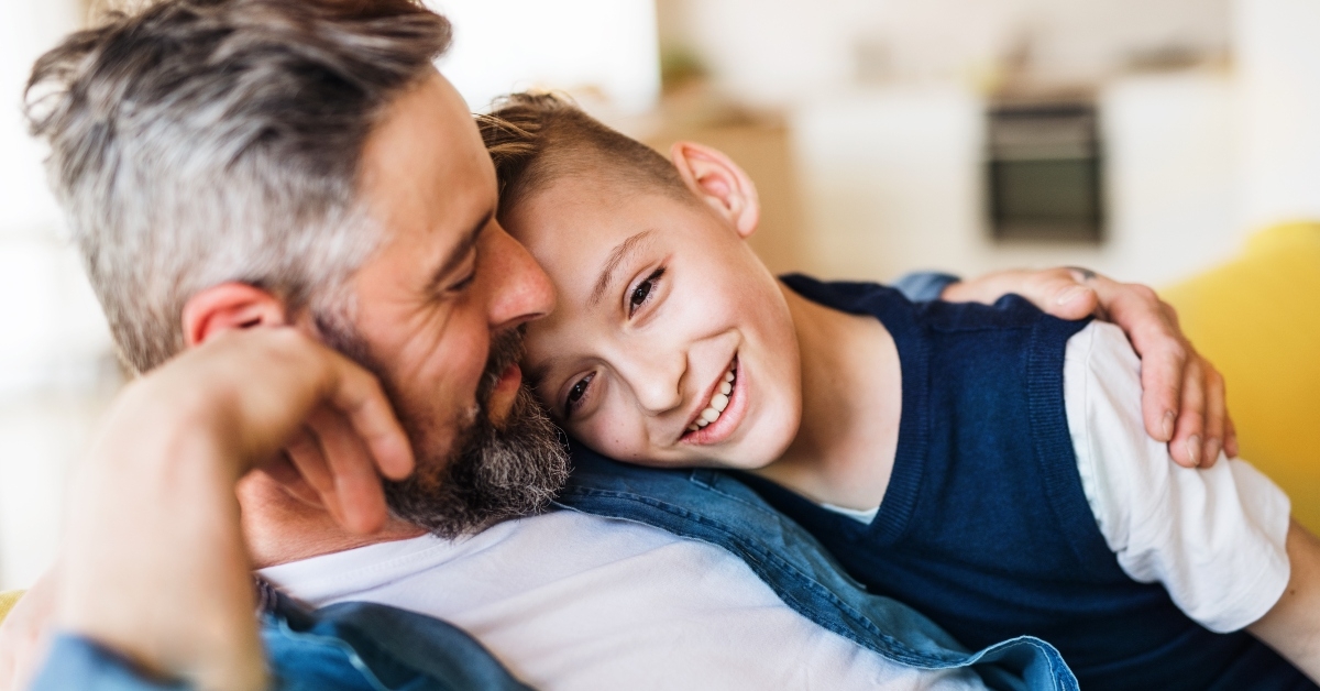 father with small son sitting on sofa indoors
