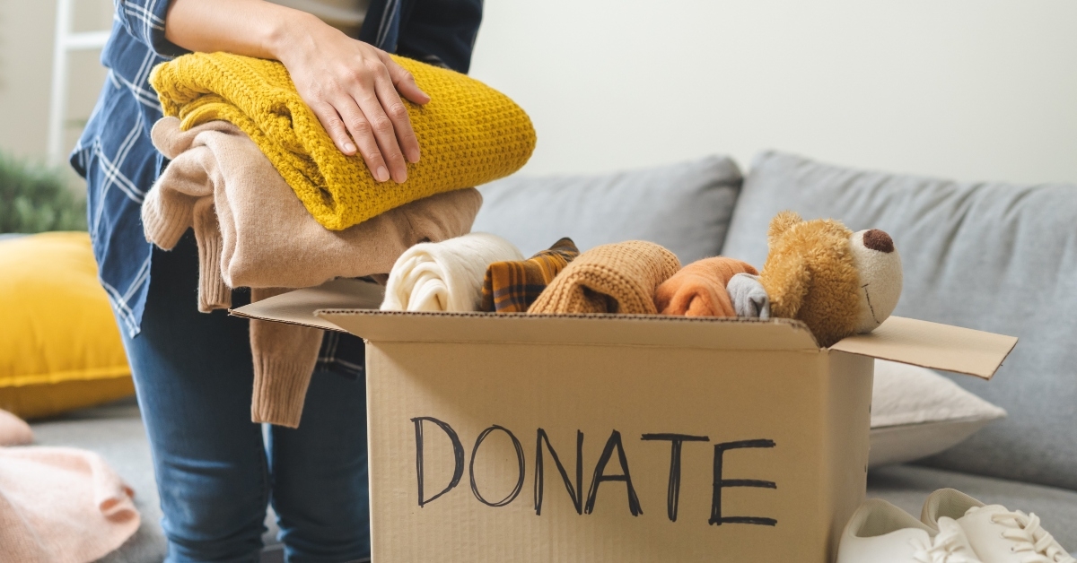 girl putting on stuff into donate box