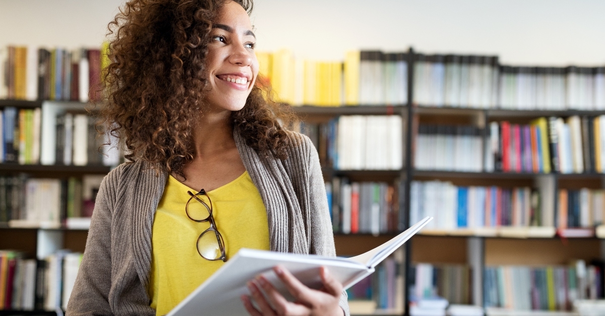 smiling female student holding a book