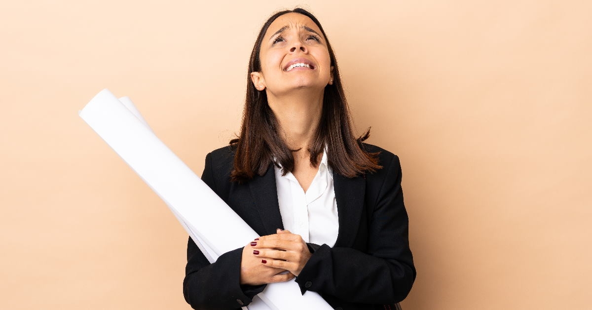 woman architect in suit standing with blue prints in hands 