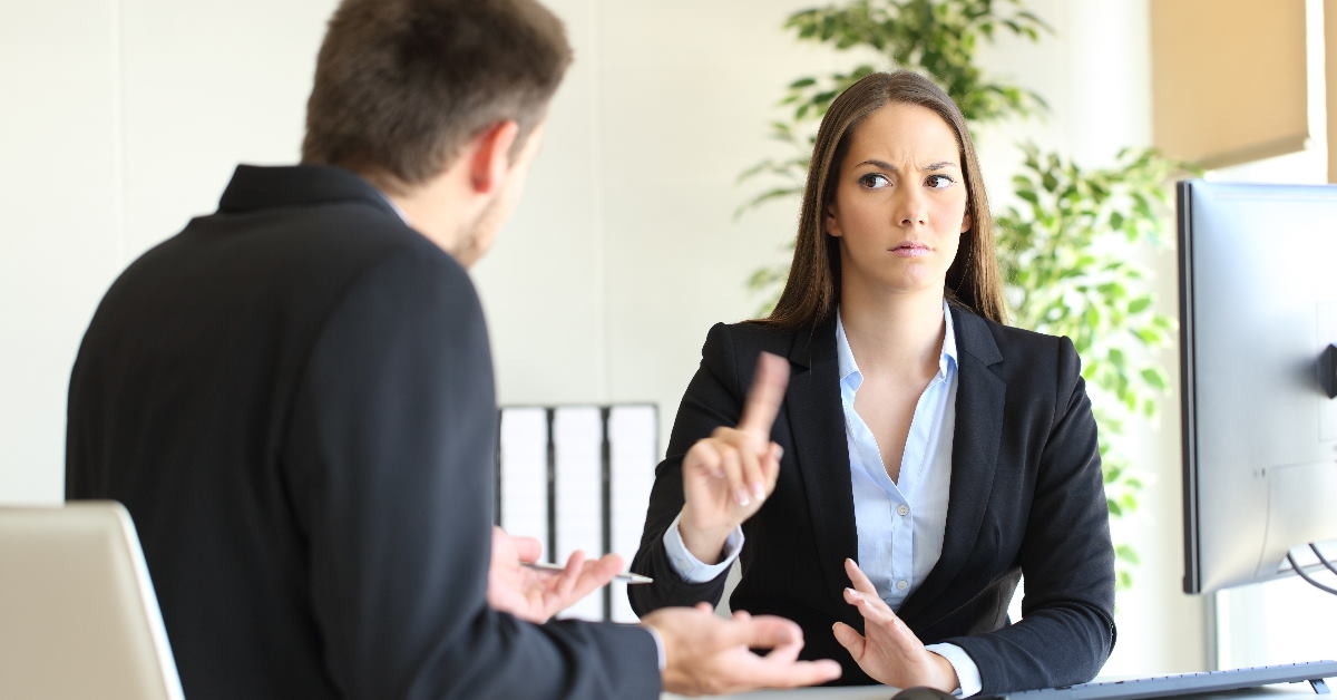 woman boss sitting in front of man colleague saying no