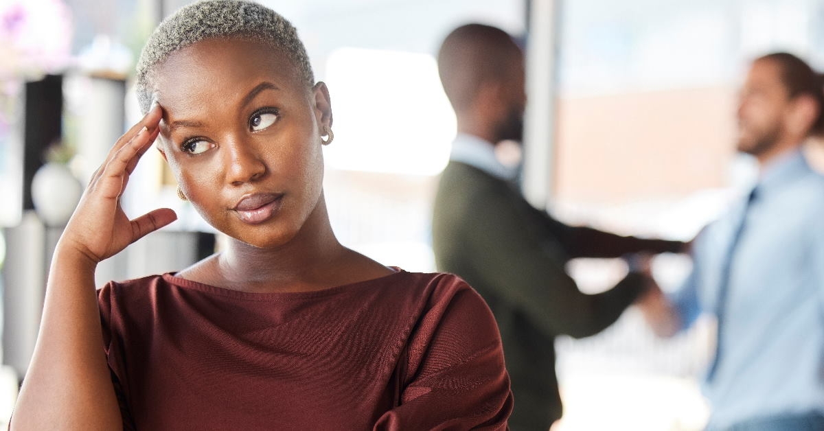 african american woman rolling eyes while standing in office