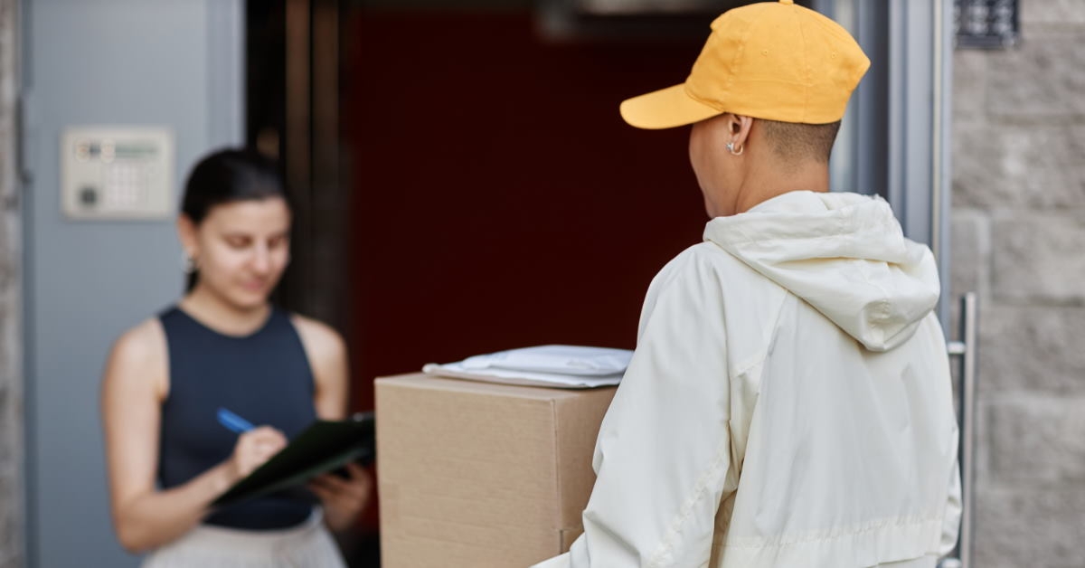 woman signing documents to receive parcel from man  