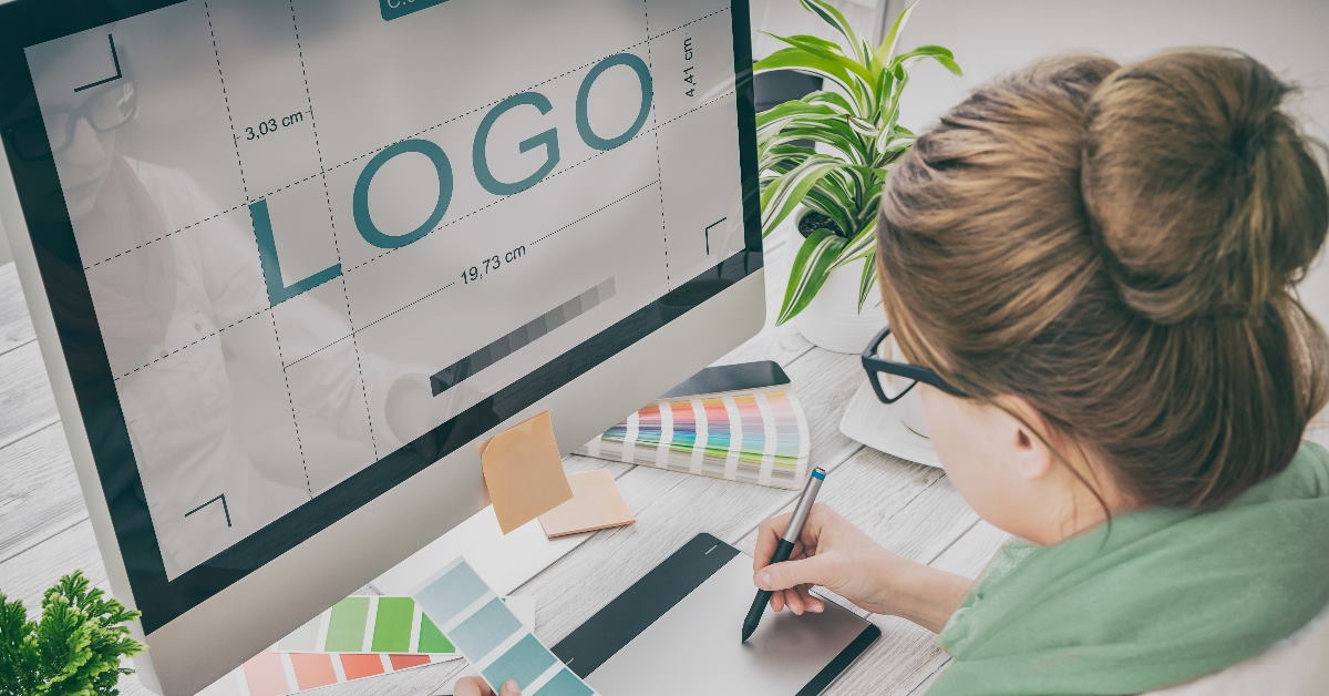 female graphic designer using creative pad to draw logo on monitor at work