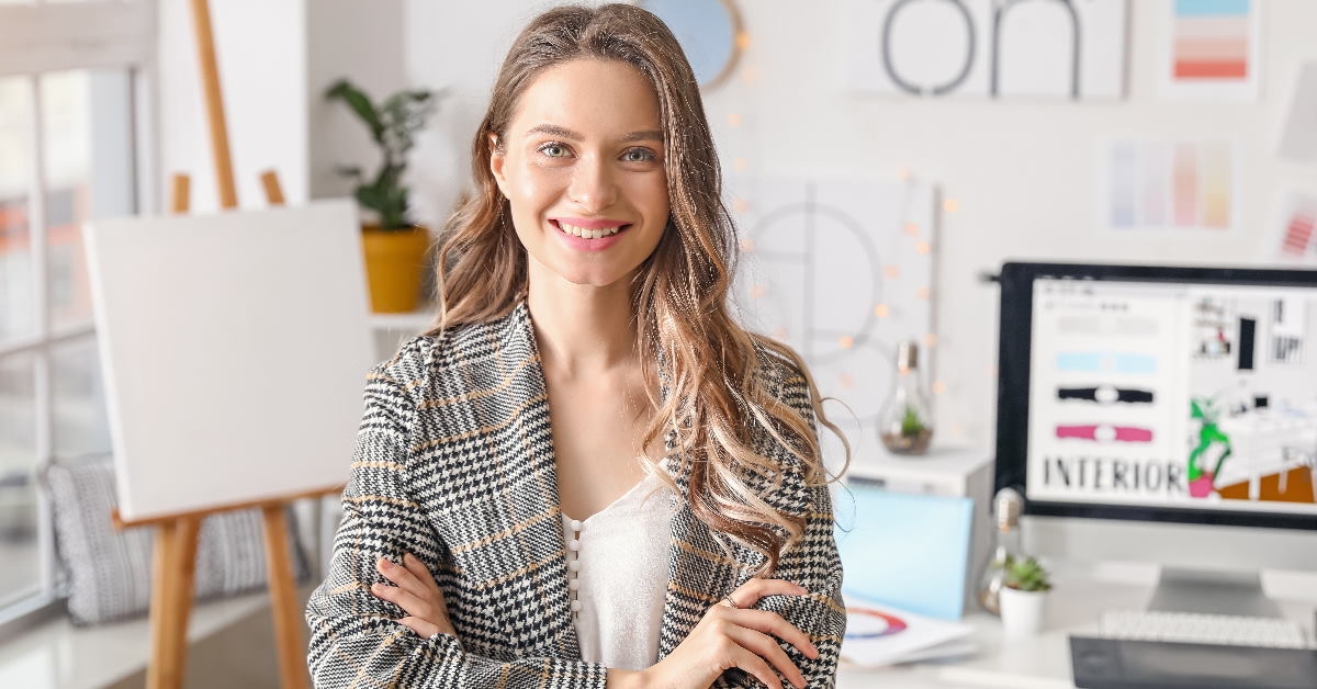 female interior designer standing in office with canvas and monitor in background
