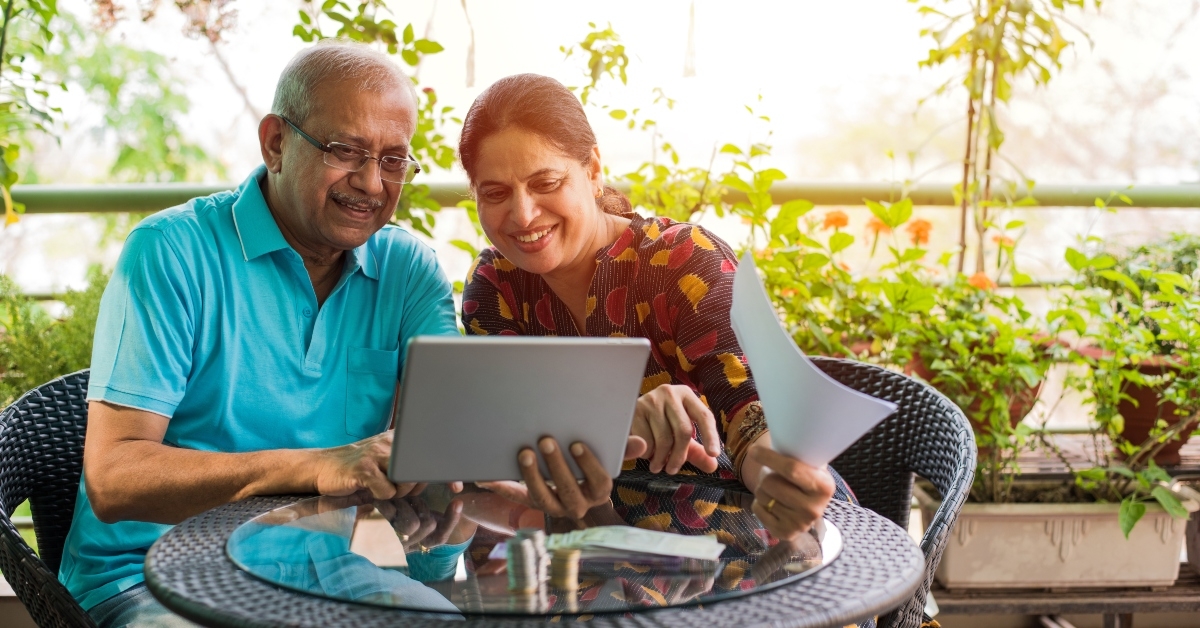 senior asian couple checking bills with laptop