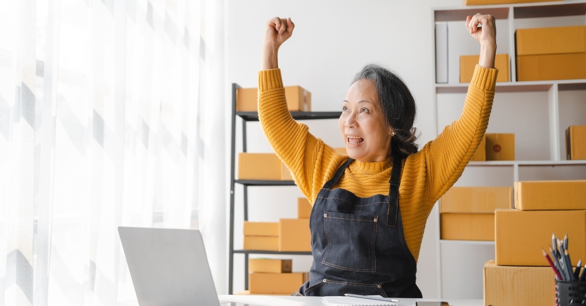 senior female business owner with product package boxes