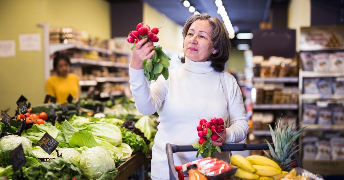 senior woman choosing bunch of fresh radishes