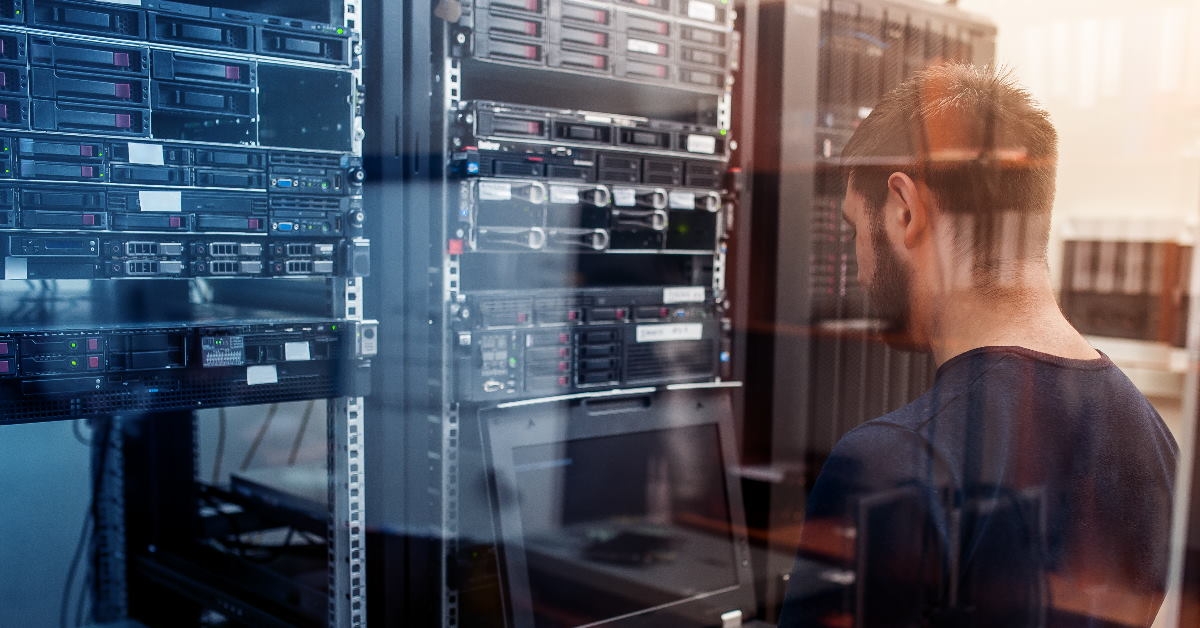 network engineer using laptop inside server room to modify network
