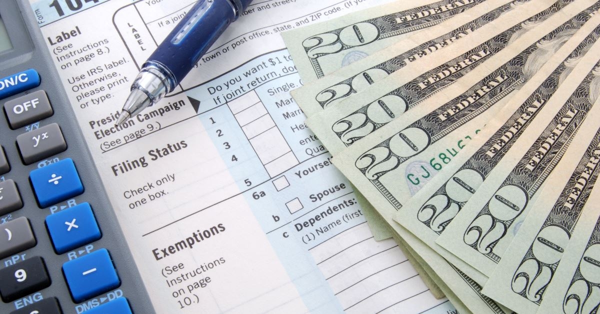 calculator and lots of twenty dollar bills on application form at table