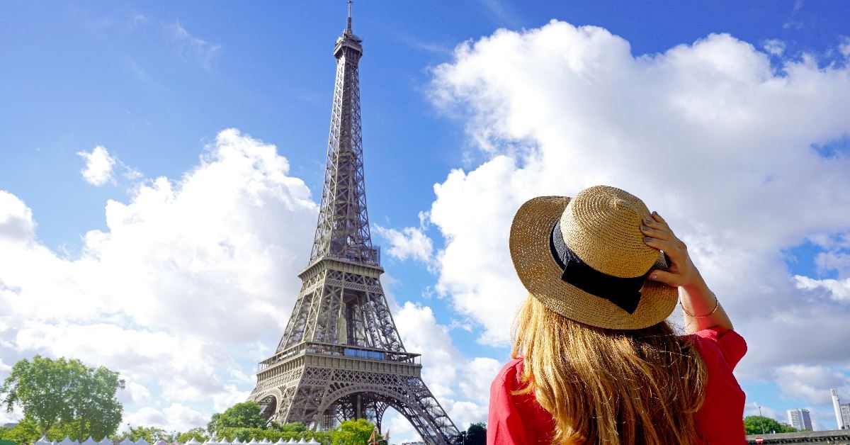 woman standing in paris street with eiffel tower in background 