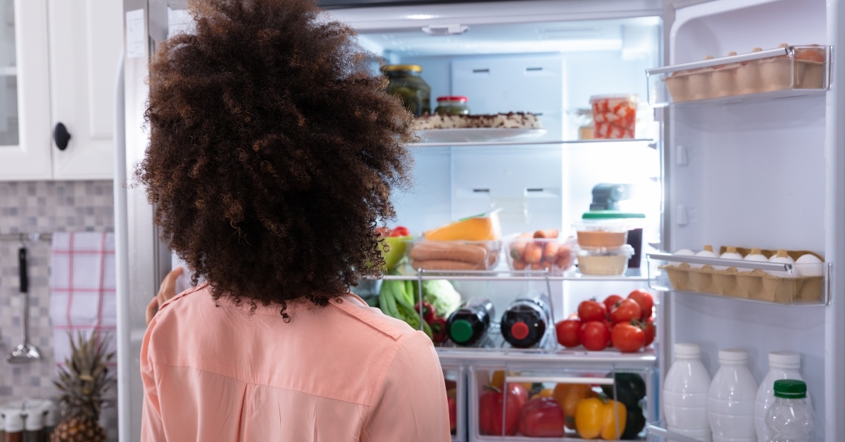 Woman searching for food in refrigerator