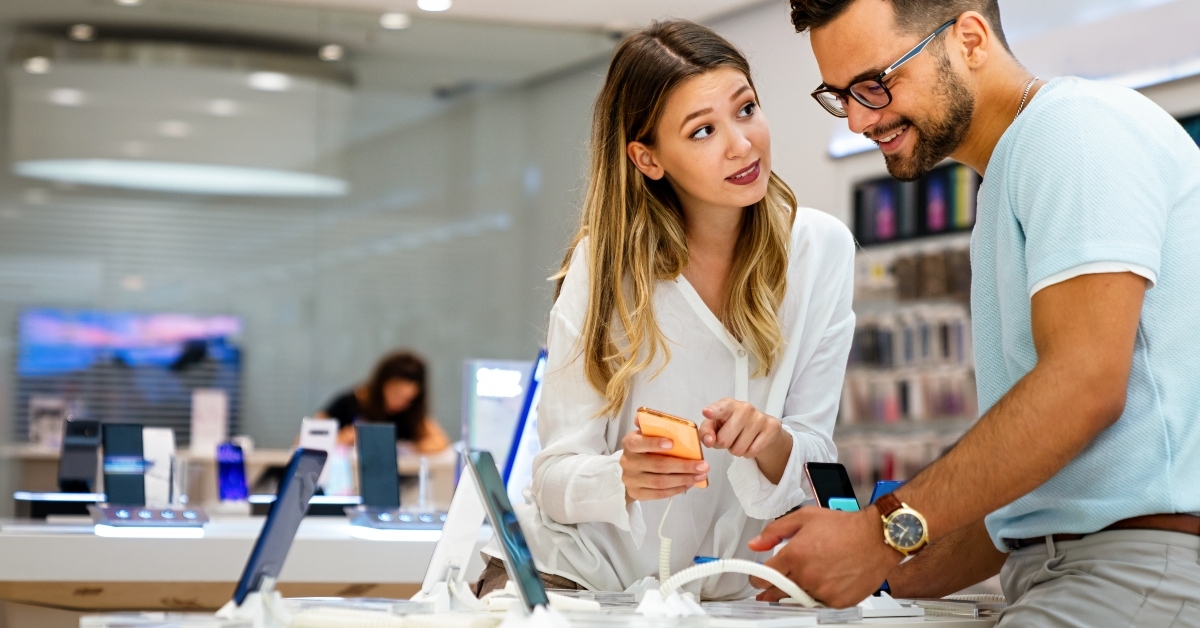 young people buying new smartphone in mobile shop