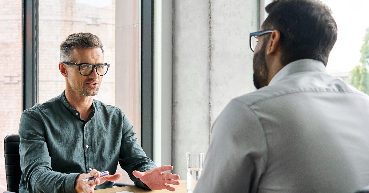 business partners sitting at table negotiating deal 