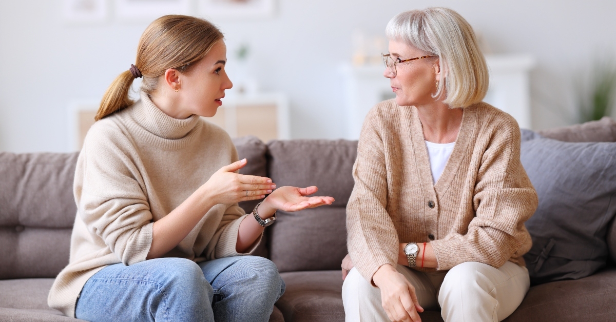 happy women chatting on sofa at home