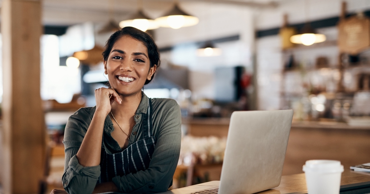 young woman using a laptop while working in a cafe