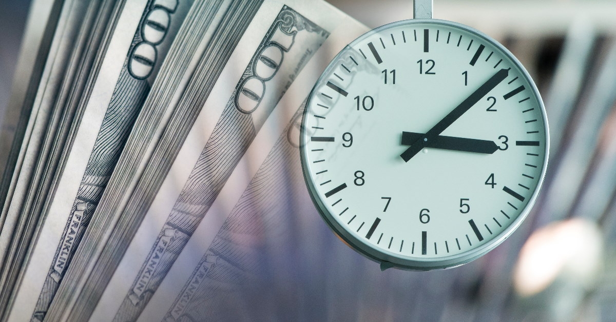 clock piece showing time on one hundred dollar bills showing time is money concept