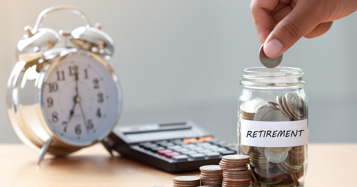 man putting pennies in glass jar with retirement label 