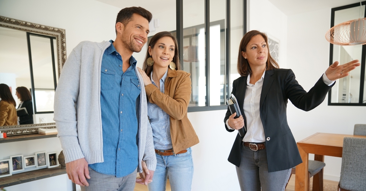 couple with real-estate agent visiting house for sale