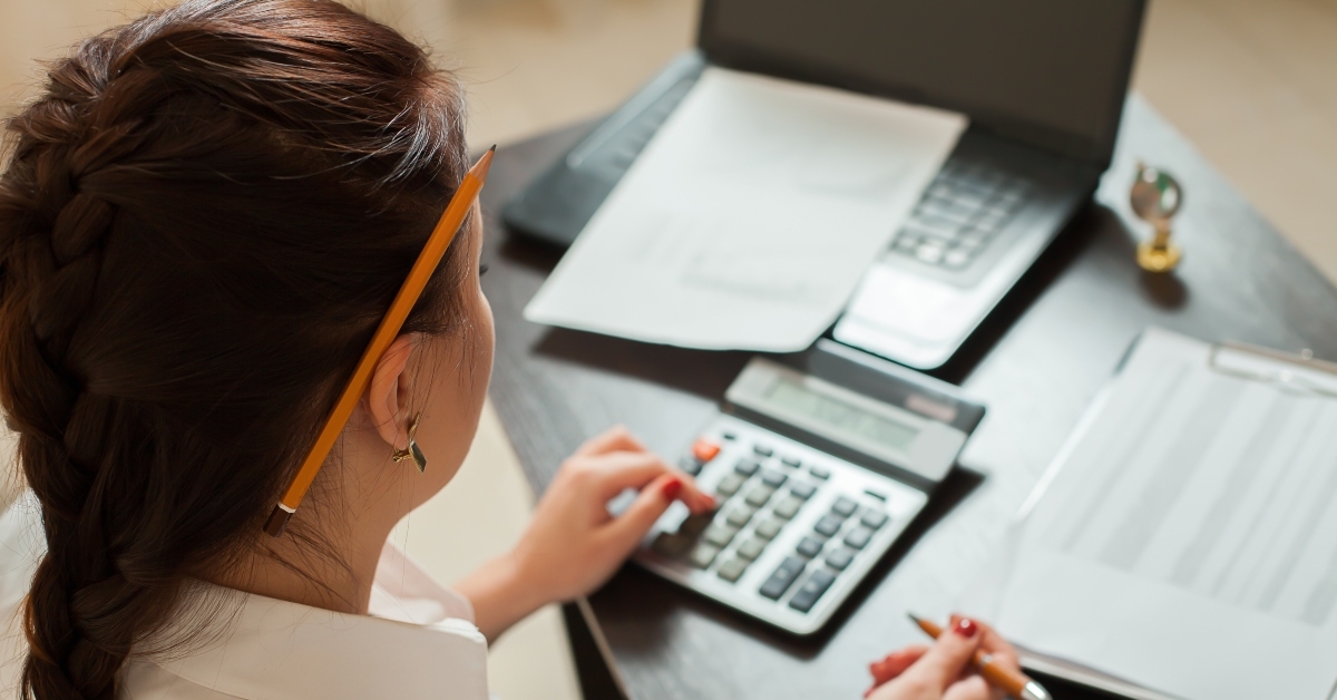 young female bookkeeper considers on calculator