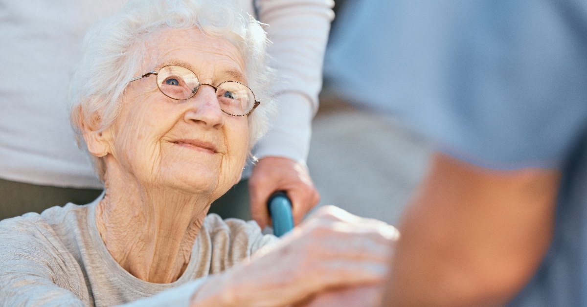 senior woman in wheelchair at retirement home holding hand of a healthcare nurse