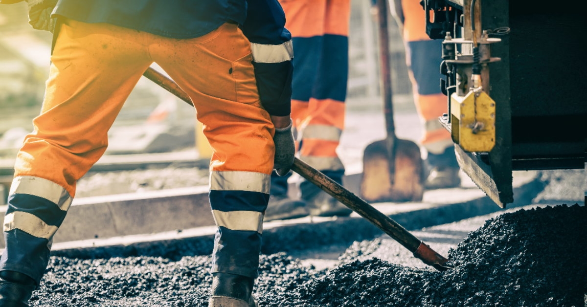 workers wearing protective gear using tools for road construction