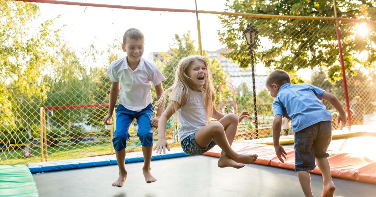 children jump on trampoline in the park
