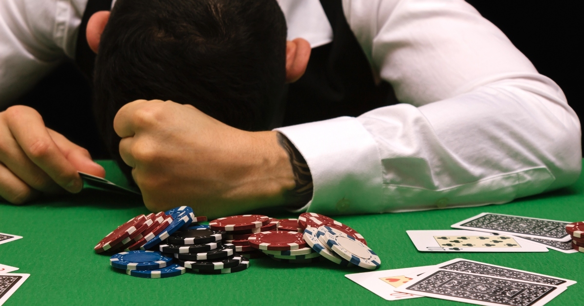 gambler man losing a lot of money playing poker in casino