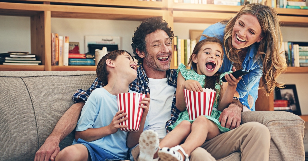 happy family watching movies on the sofa at home