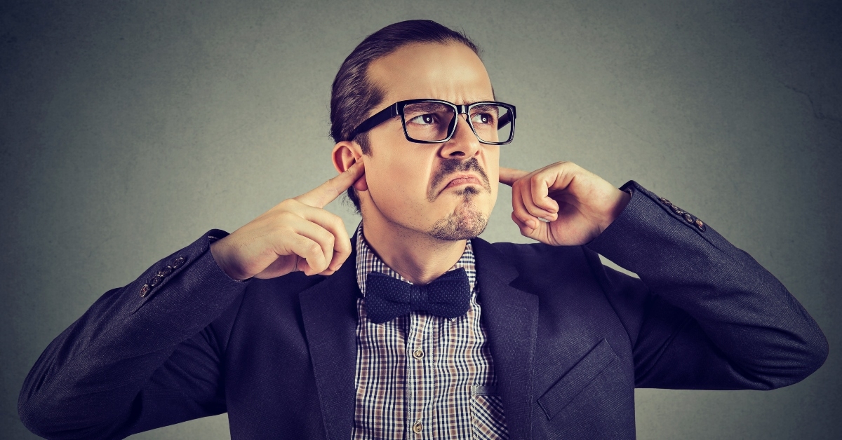 stubborn young man covering ears