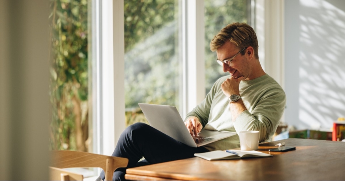 young man using laptop and smiling