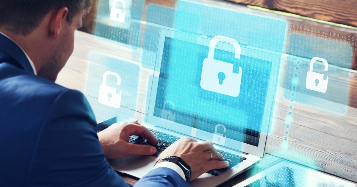 businessman sitting at table in office working on laptop