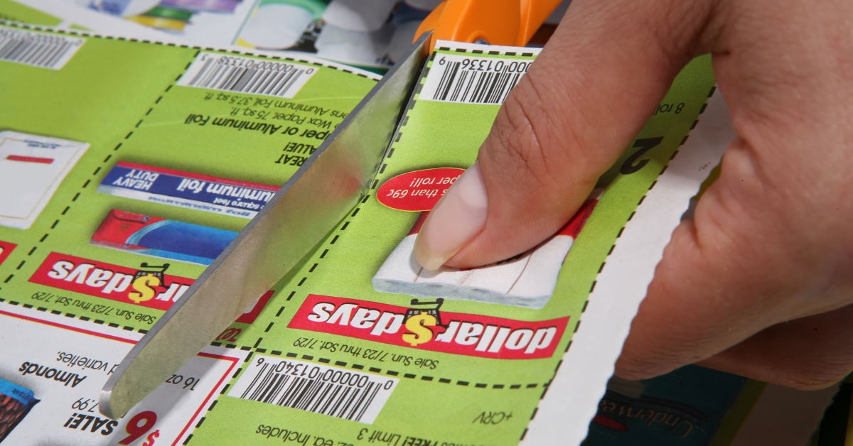 Woman using scissor to cut discount coupons